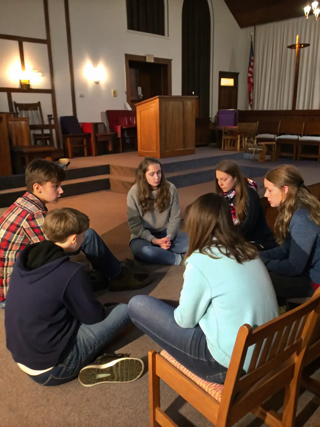A group of teenagers laughing and studying the Bible together in a brightly lit room, symbolizing engaging Bible studies.